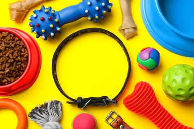 Photo of Flat lay composition with dog collar, toys and food on yellow background