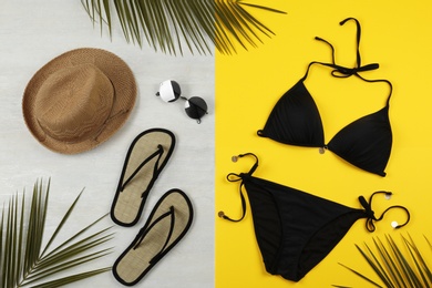 Photo of Flat lay composition with black swimsuit and beach accessories on color background