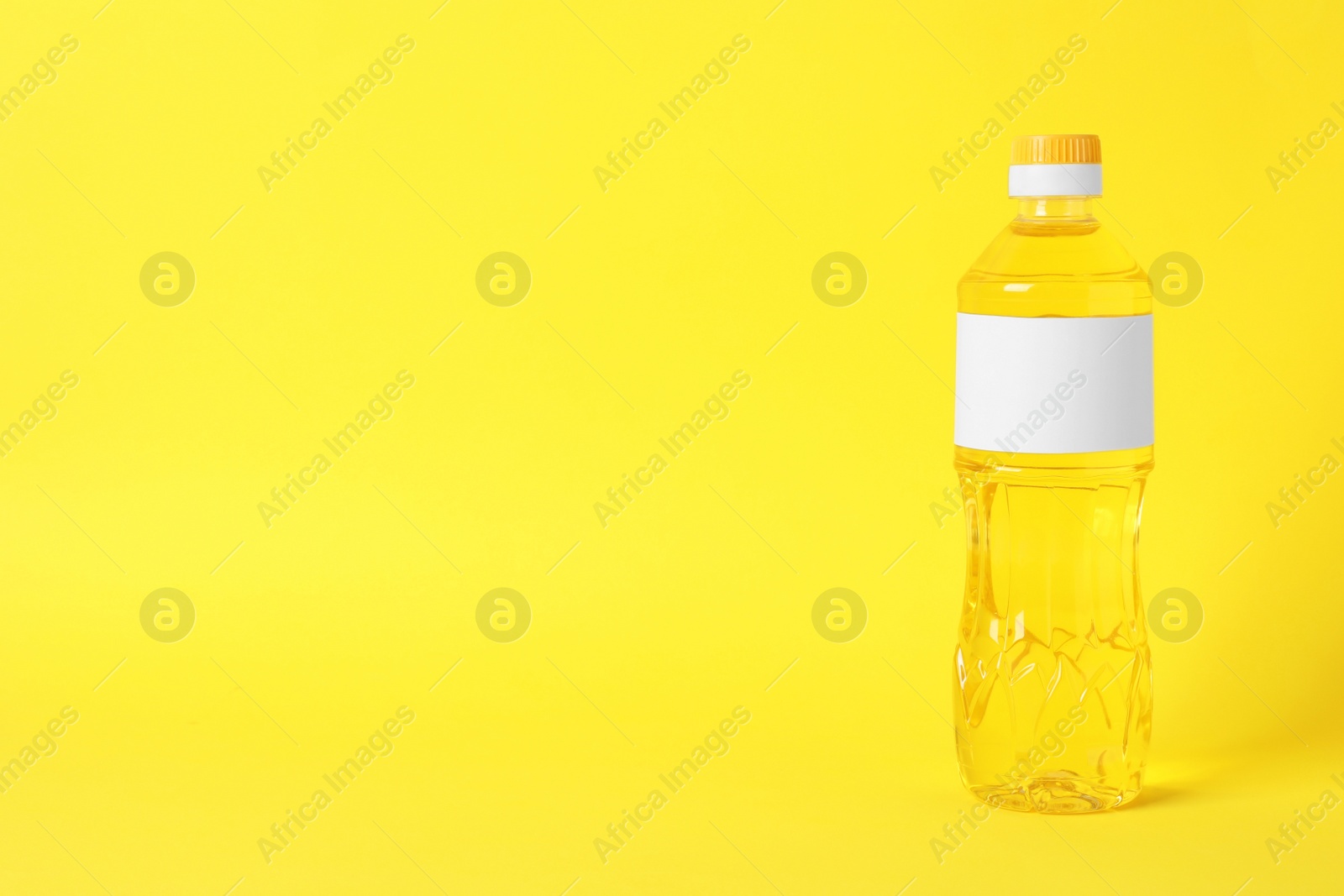 Photo of Bottle of cooking oil on yellow background. Space for text