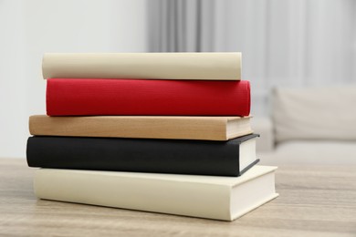 Stack of hardcover books on wooden table indoors