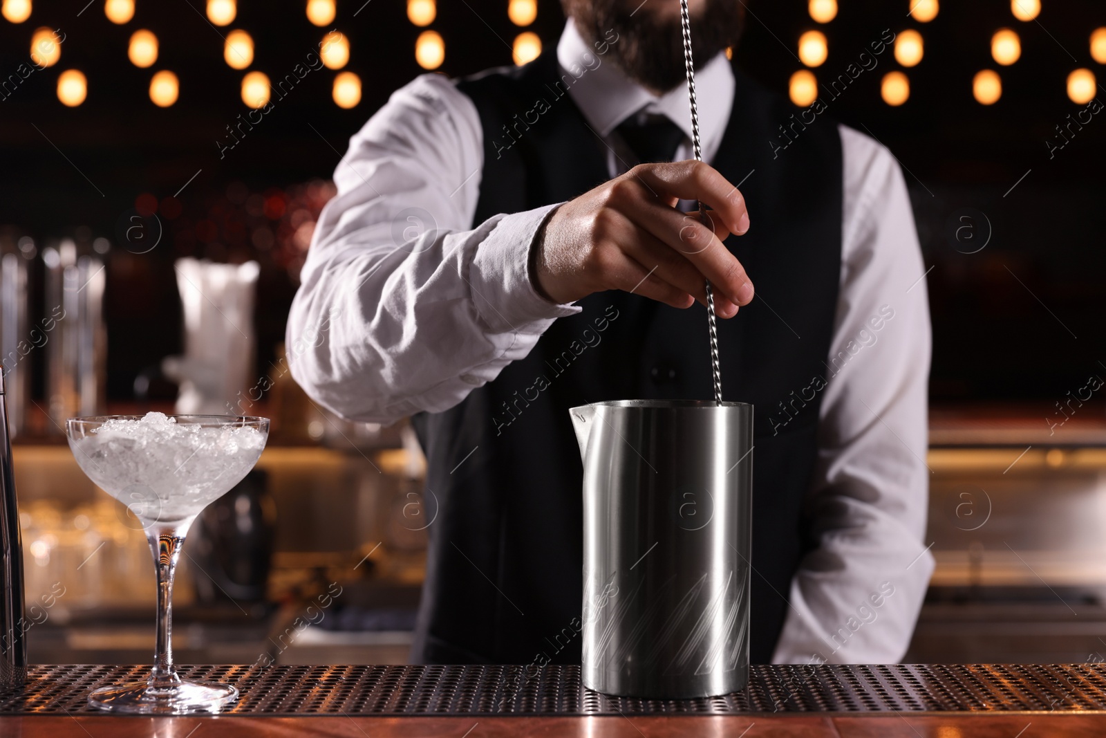 Photo of Bartender preparing fresh alcoholic cocktail at bar counter, closeup