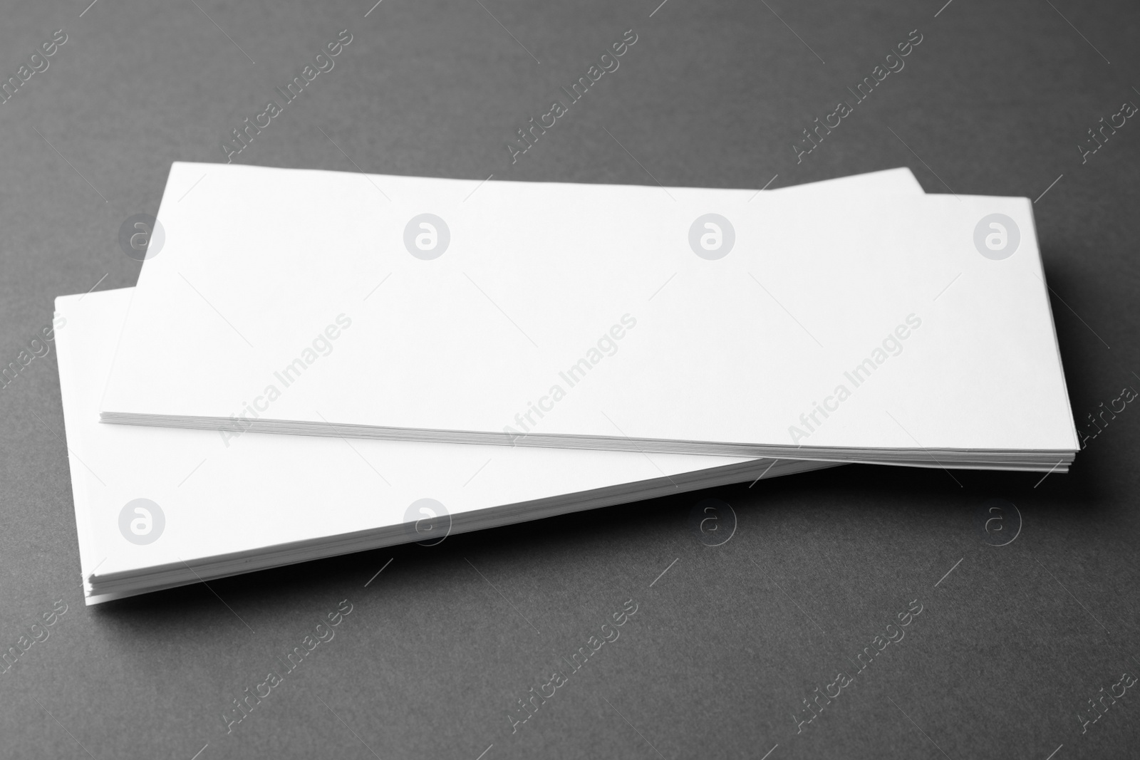 Photo of Blank business cards on dark grey background, closeup. Mock up for design