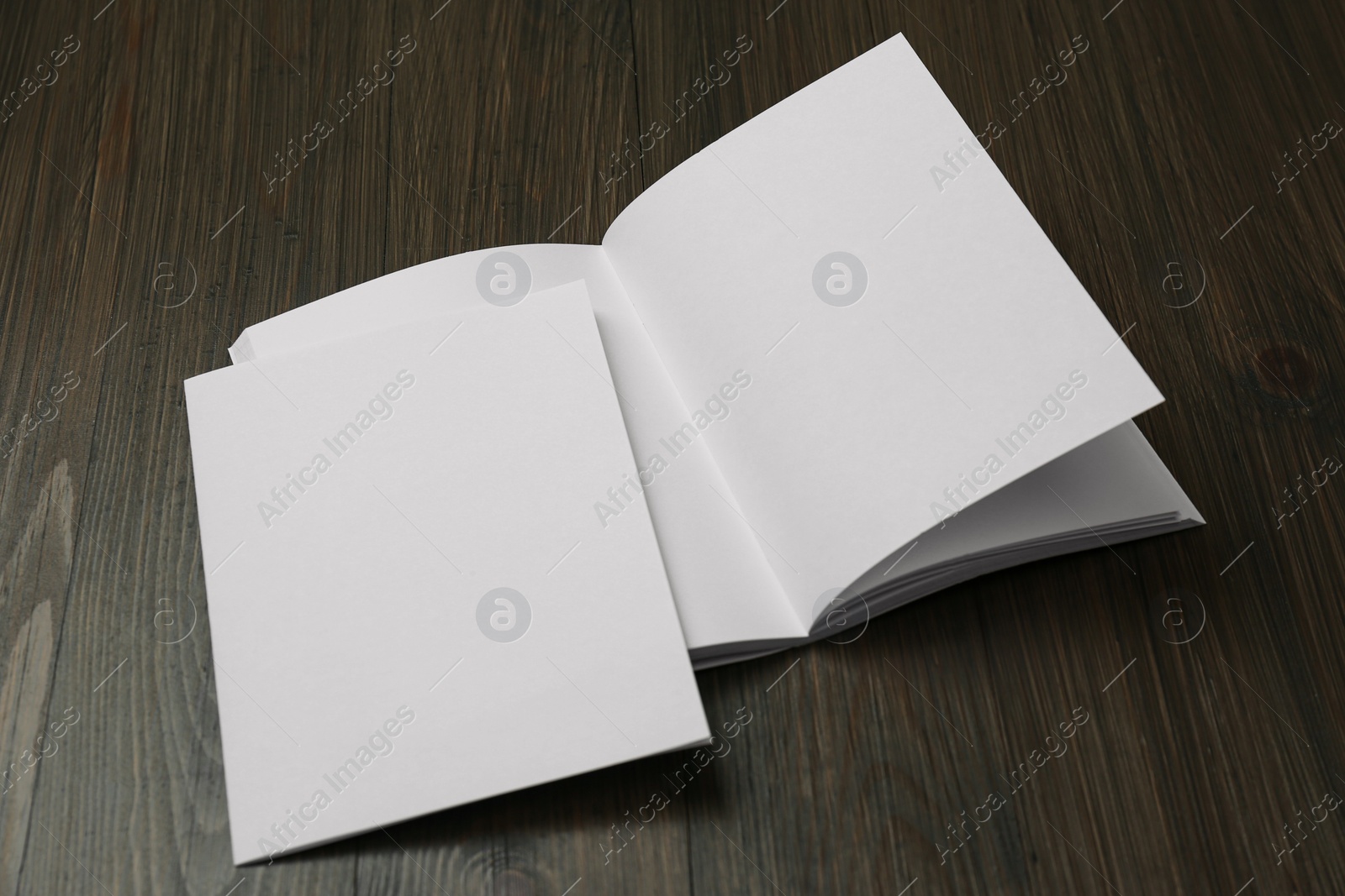 Photo of Sheet of paper and blank brochure on wooden table. Mockup for design