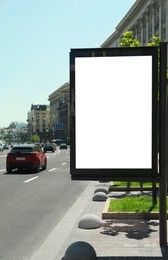 Photo of Blank advertising board on city street. Mockup for design