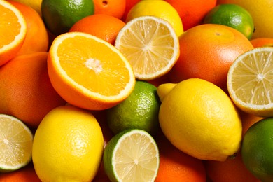 Different fresh citrus fruits as background, closeup