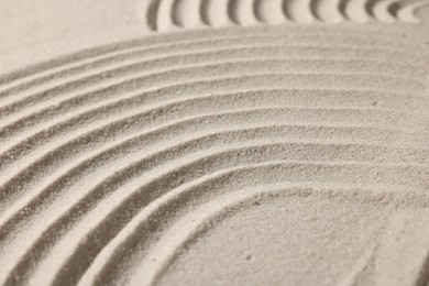 Photo of Beautiful lines drawn on sand, closeup. Zen garden