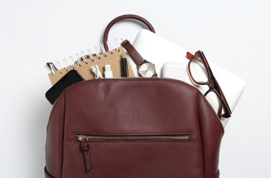 Photo of Stylish urban backpack with different items on white background, top view