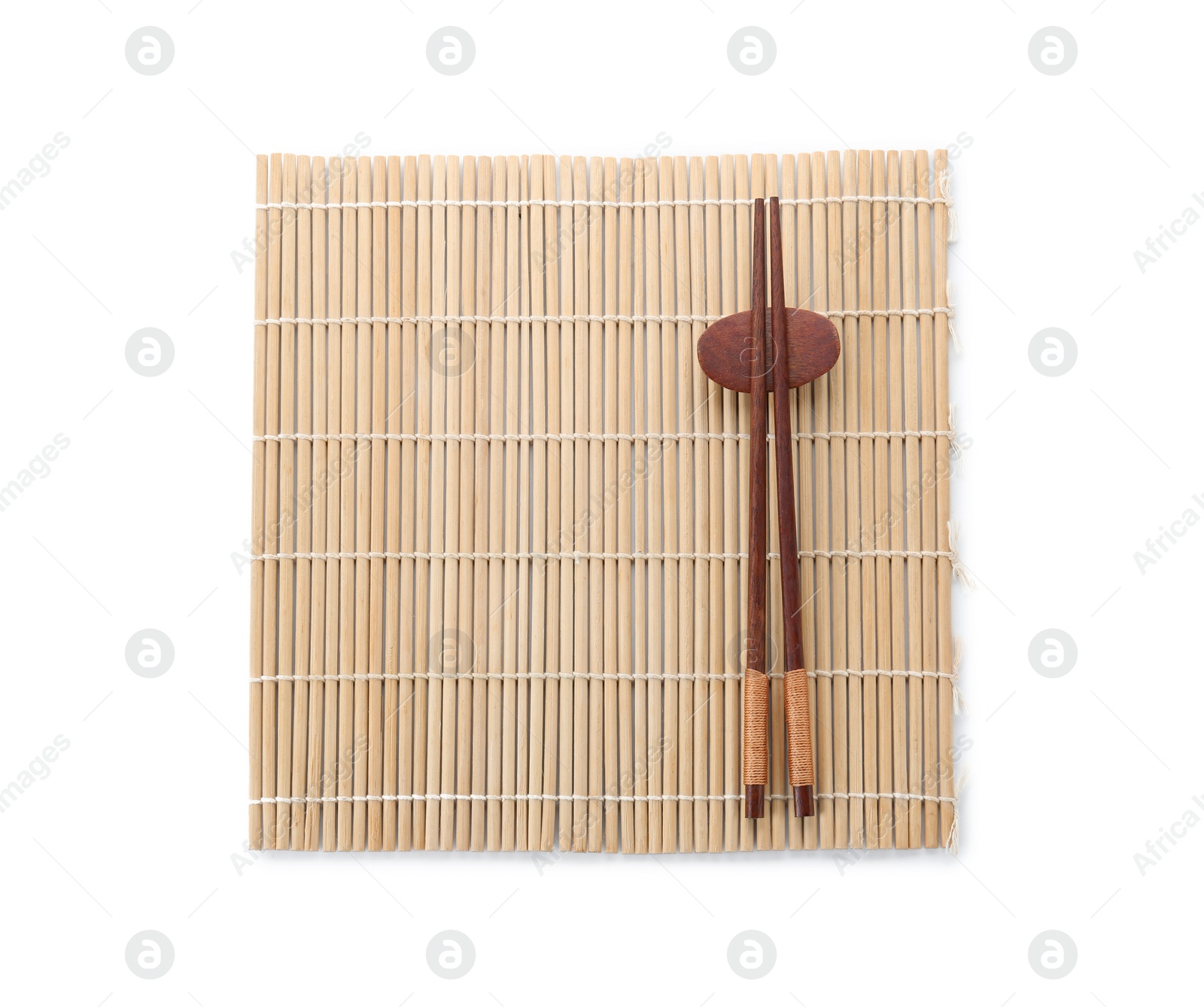 Photo of Bamboo mat with pair of wooden chopsticks and rest isolated on white, top view