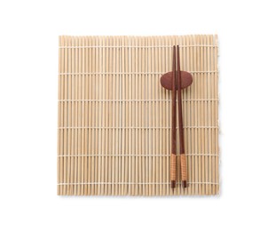 Photo of Bamboo mat with pair of wooden chopsticks and rest isolated on white, top view