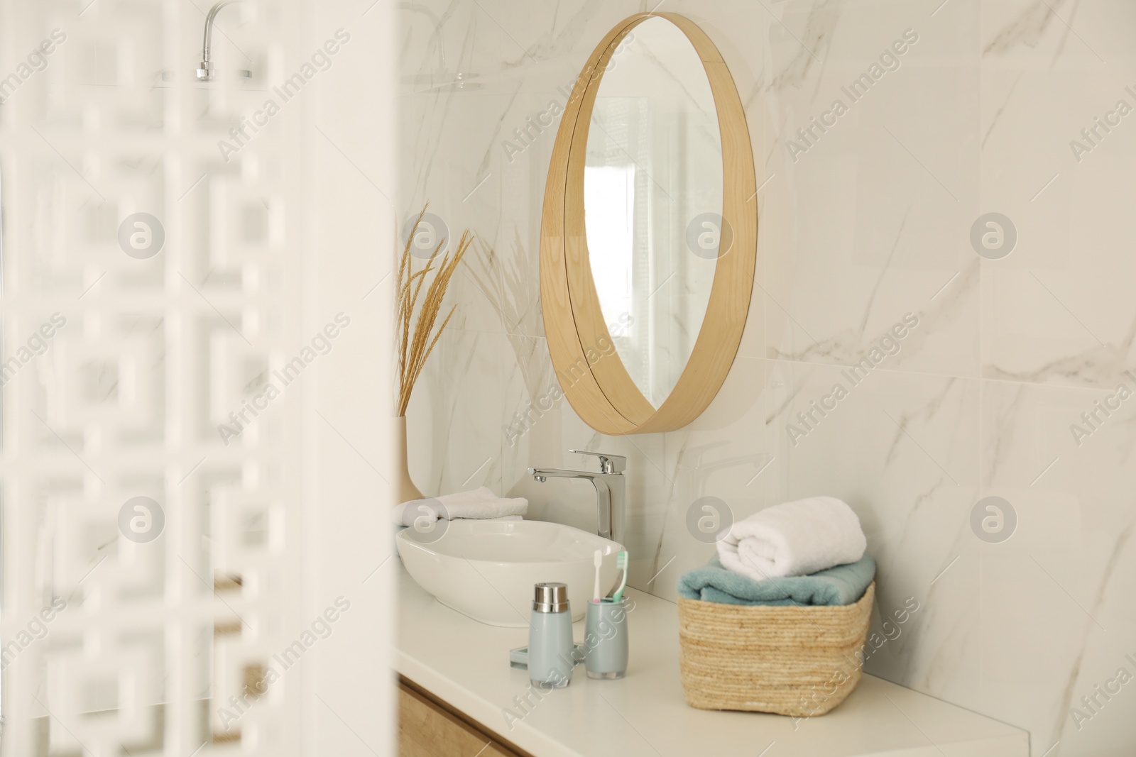 Photo of Round mirror over vessel sink in stylish bathroom interior