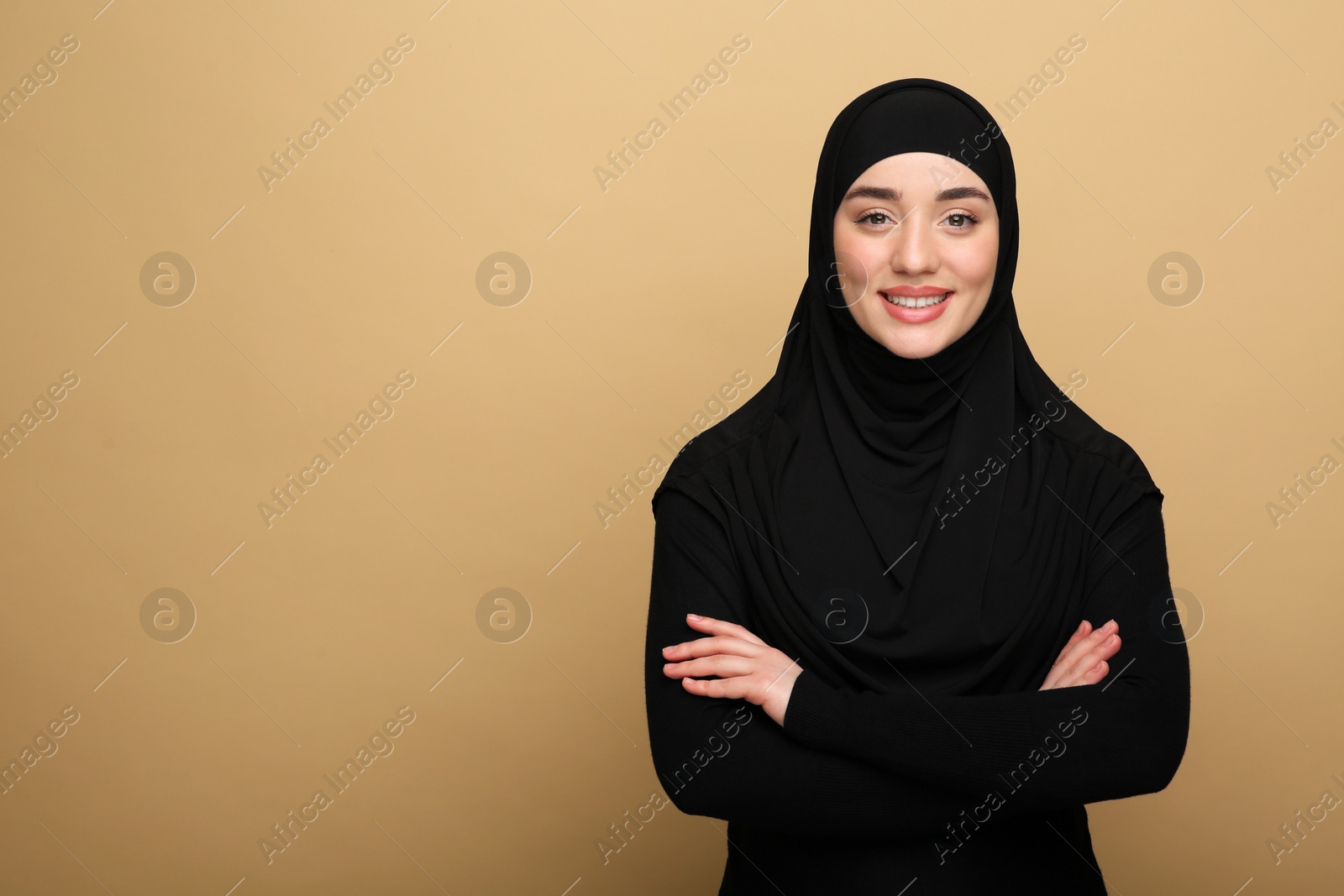 Photo of Portrait of Muslim woman in hijab on beige background, space for text