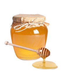 Natural honey dripping from dipper. Jar full of honey on white background