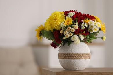 Photo of Bouquet of beautiful chrysanthemum flowers on table in room, space for text