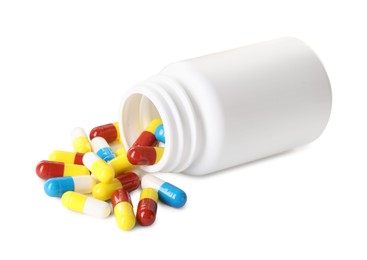 Scattered antibiotic pills and bottle isolated on white