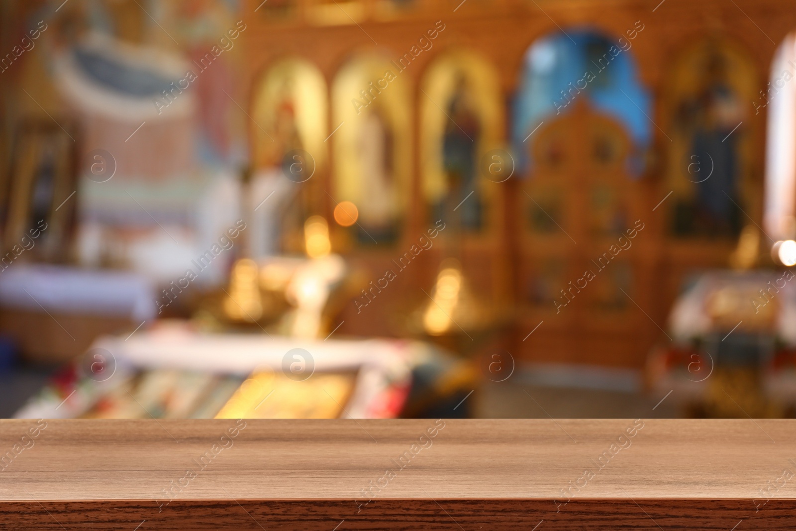 Image of Empty wooden table and blurred view of beautiful church interior, space for text