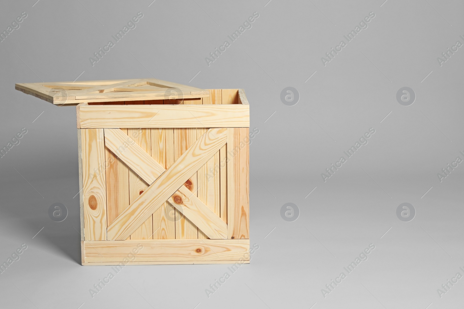 Photo of Open wooden crate on grey background. Space for text