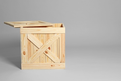 Photo of Open wooden crate on grey background. Space for text