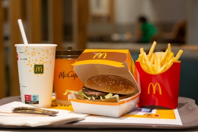 WARSAW, POLAND - SEPTEMBER 04, 2022: McDonald's French fries, burger and drinks on table indoors