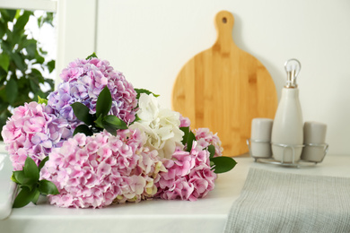 Beautiful bouquet of hydrangea flowers on light countertop, closeup