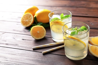 Photo of Glasses with natural lemonade on wooden table