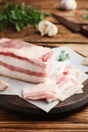Photo of Tasty salt pork with parsley on wooden table