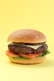 Photo of Burger with delicious patty on yellow background