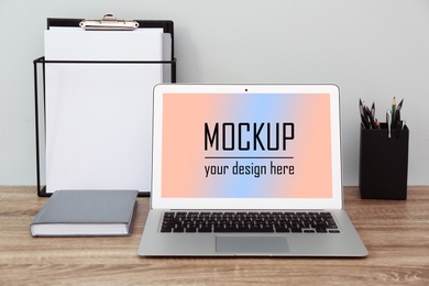 Modern laptop with text Mockup Your Design Here on screen