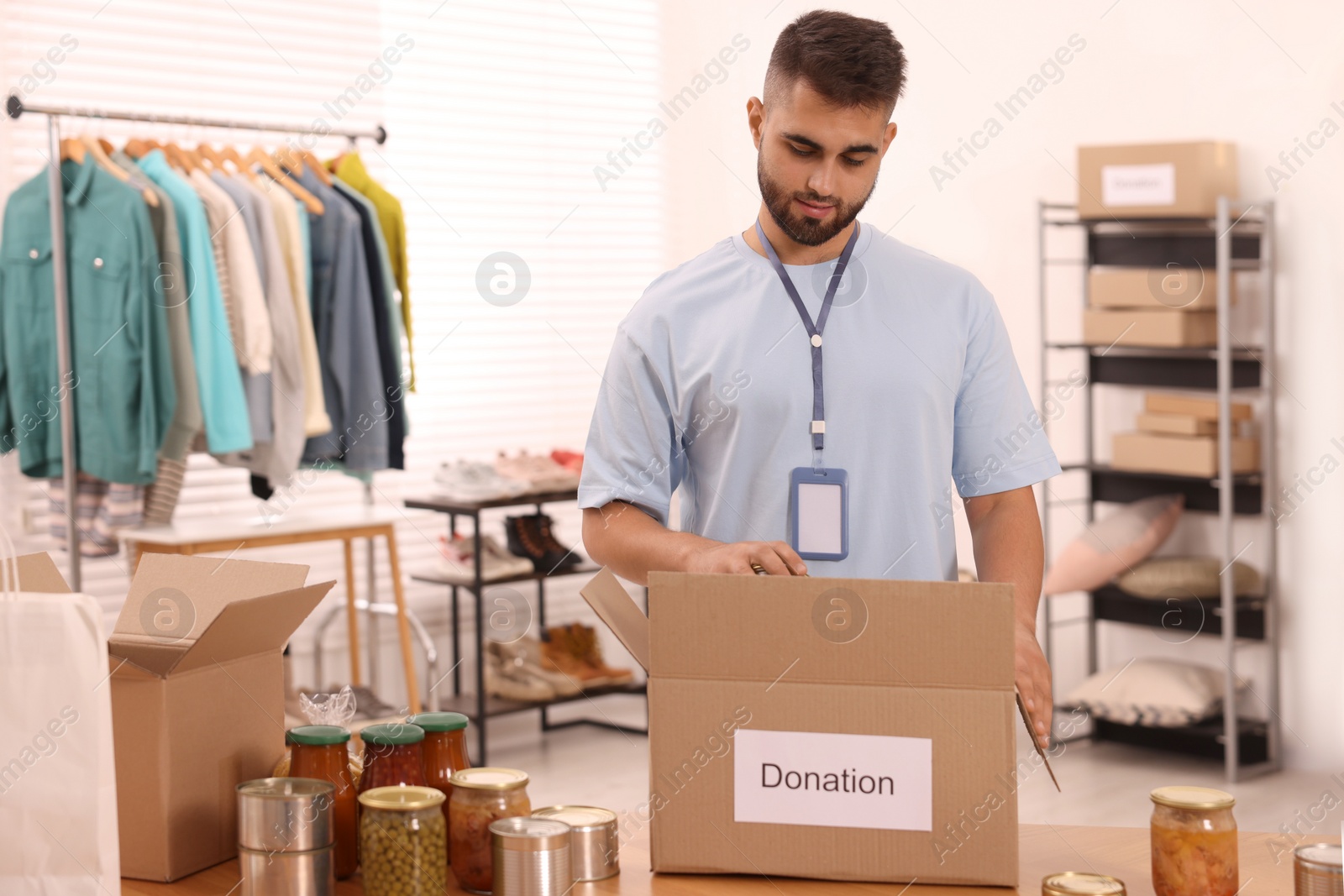 Photo of Volunteer packing food products at table in warehouse