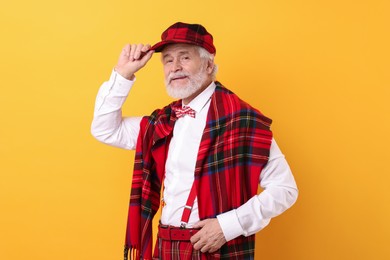 Photo of Portrait of grandpa with stylish hat and bowtie on yellow background
