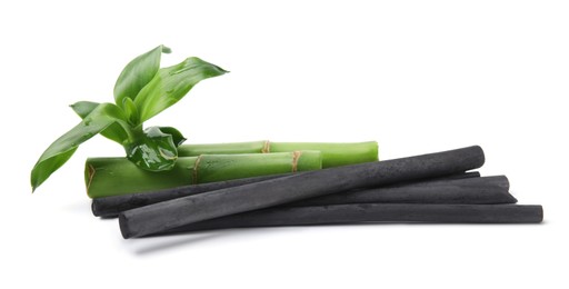 Photo of Fresh bamboo and charcoal on white background