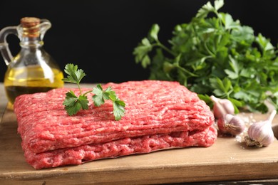 Photo of Raw ground meat, garlic, oil and parsley on table