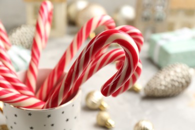 Photo of Many sweet candy canes in cup, closeup. Traditional Christmas treat