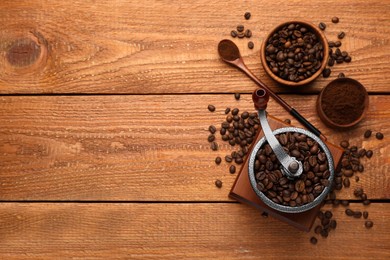 Vintage manual coffee grinder with beans and powder on wooden table, flat lay. Space for text