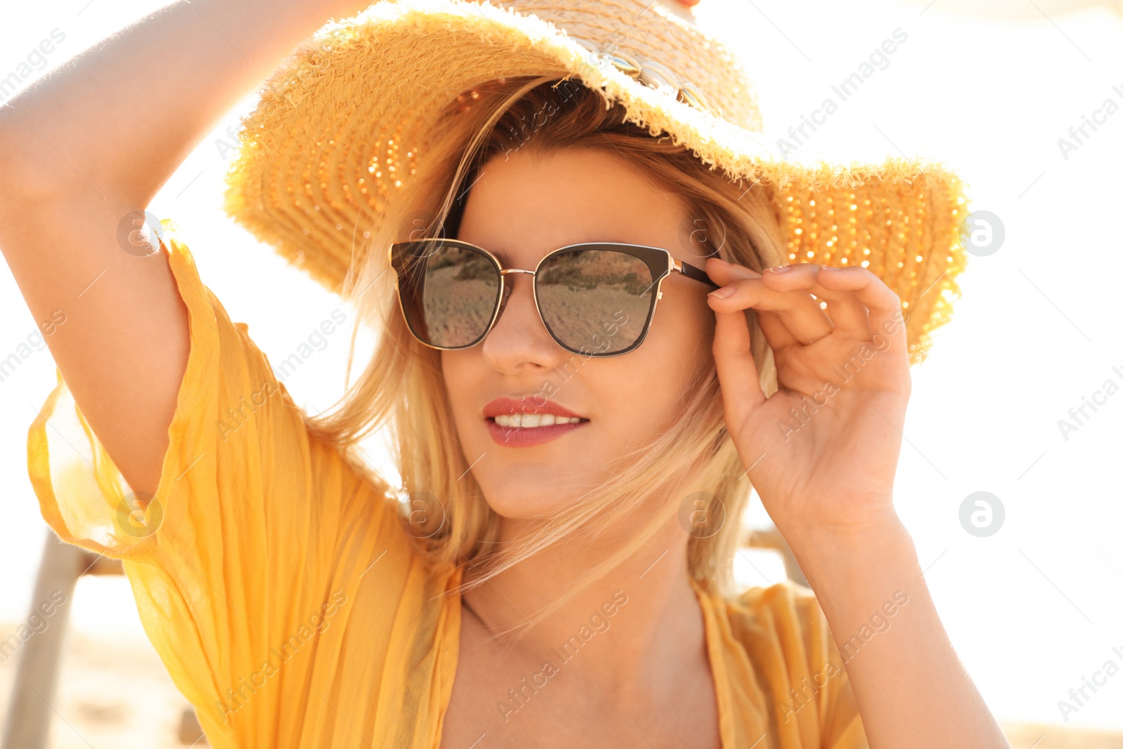 Photo of Beautiful woman wearing sunglasses outdoors on sunny day, closeup