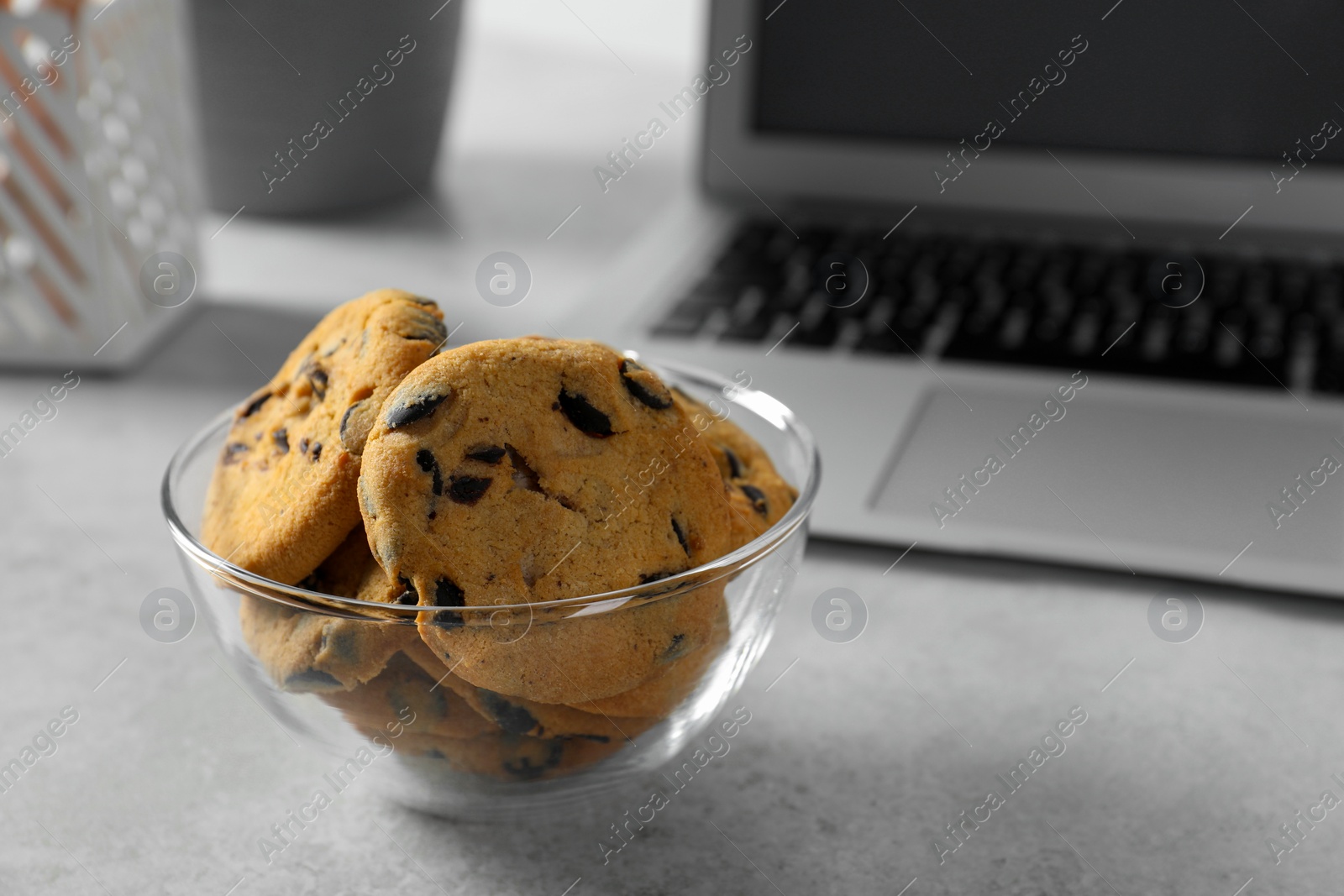 Photo of Chocolate chip cookies on light gray table at workplace. Space for text