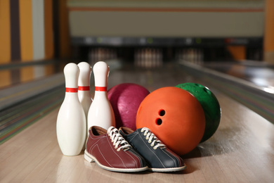 Photo of Shoes, pins and balls on bowling lane in club