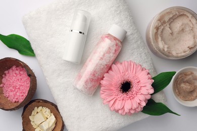 Flat lay composition with different spa products and beautiful flower on white table