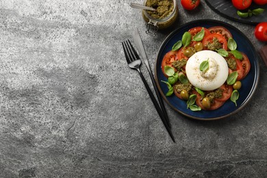 Delicious burrata salad served on grey table, flat lay. Space for text