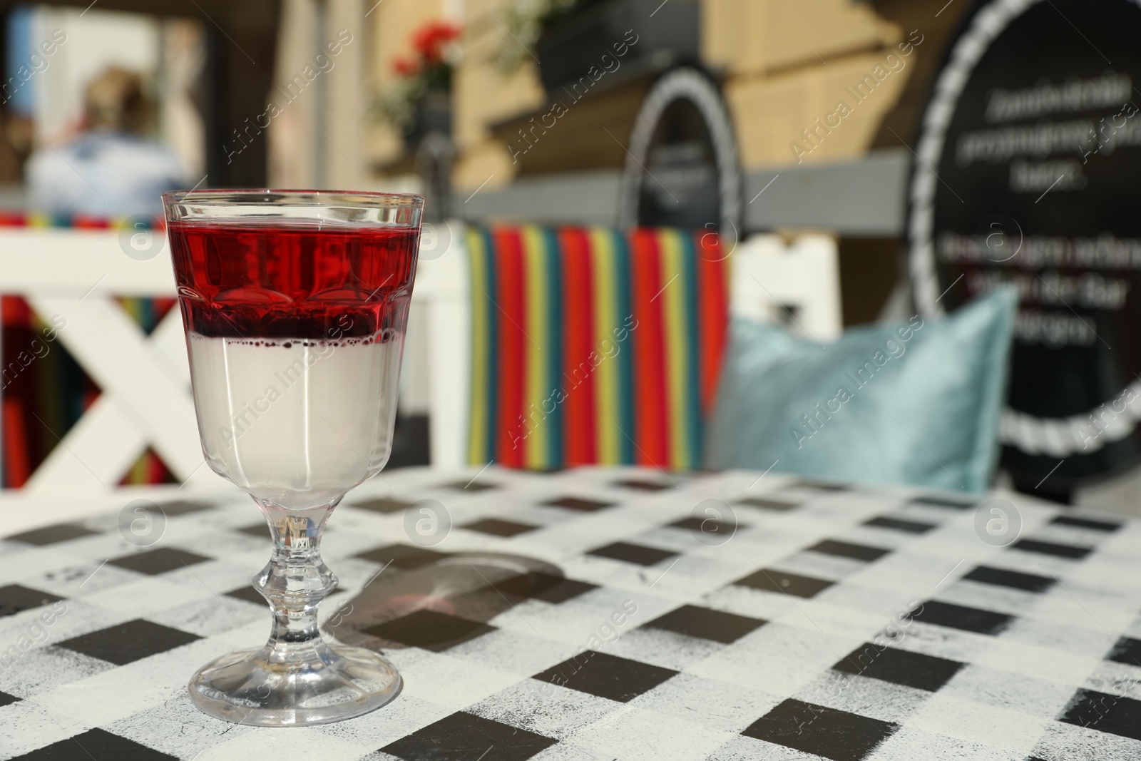 Photo of Delicious panna cotta dessert with berries on table in cafe. Space for text