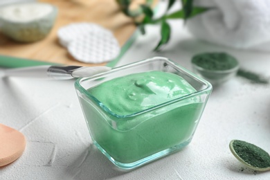Photo of Spirulina facial mask and brush on white table