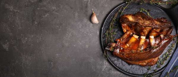 Image of Slate plate with delicious roasted ribs and space for text on grey table, top view. Banner design