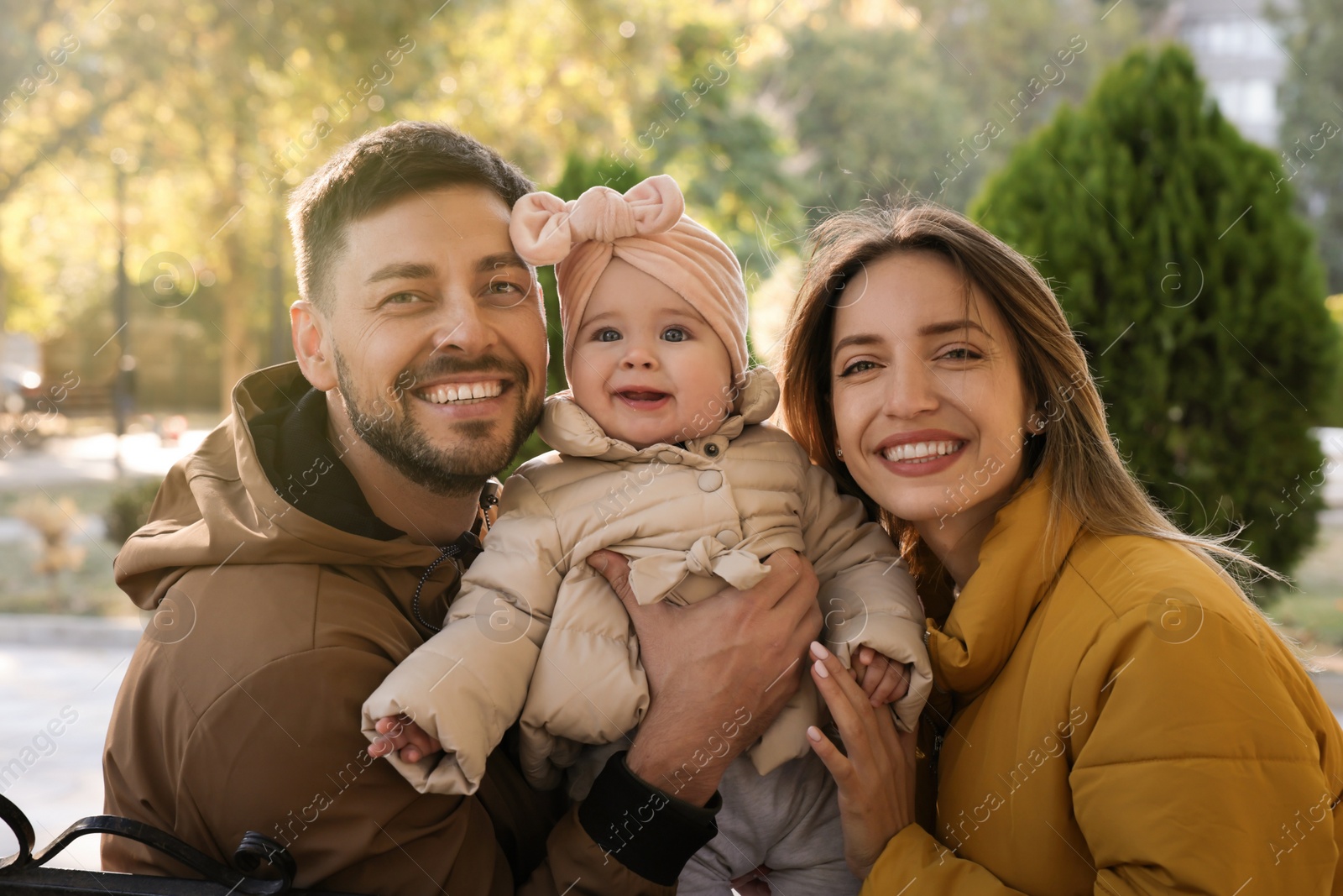 Photo of Happy parents with their baby in park on sunny day