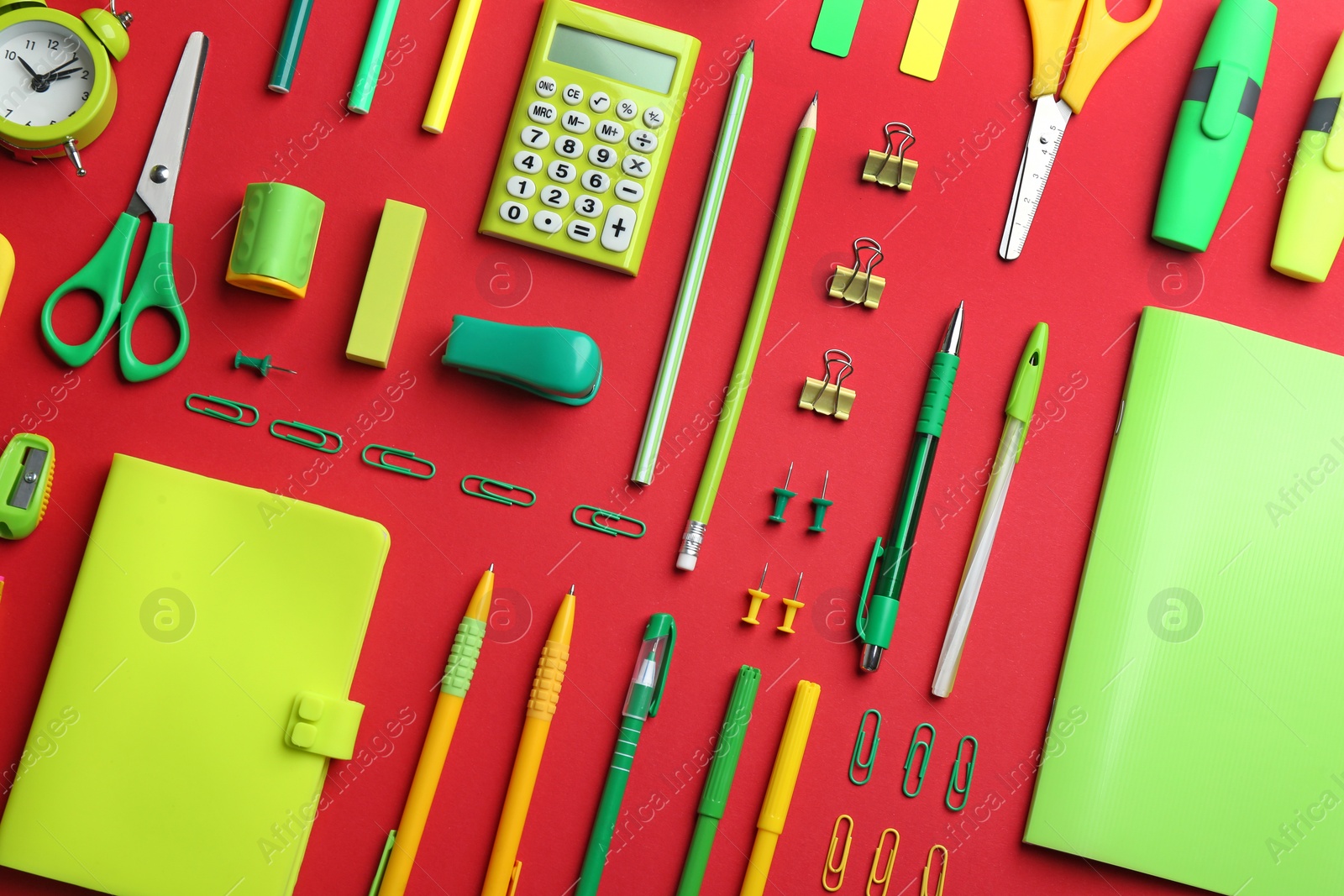 Photo of Green school stationery on red background, flat lay