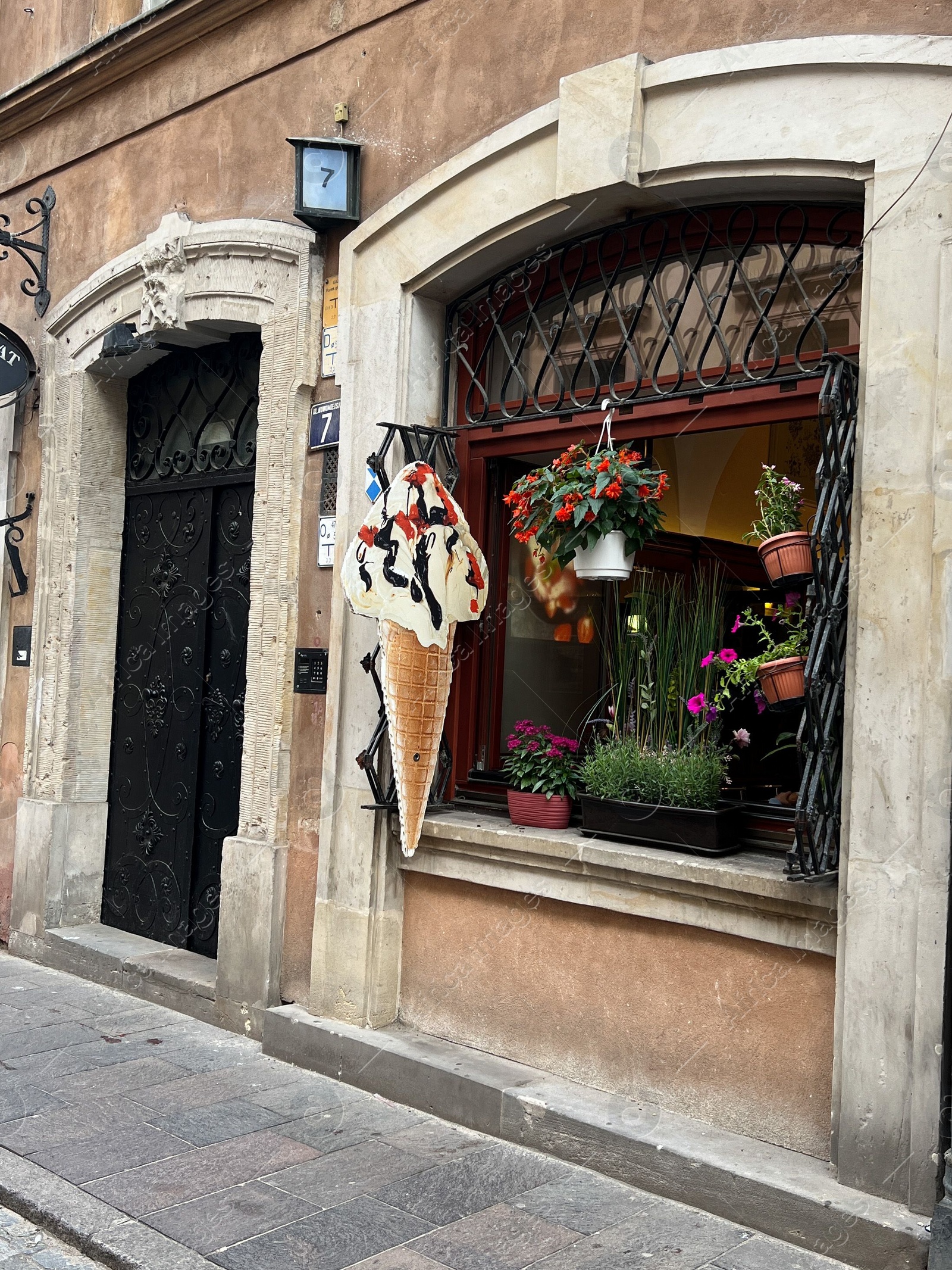 Photo of WARSAW, POLAND - JULY 17, 2022: Building with open window and flower decor, view from outdoors