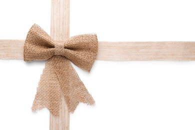 Burlap ribbons with pretty bow on white background, top view