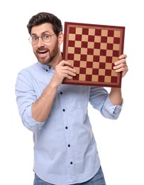 Photo of Emotional man holding chessboard on white background