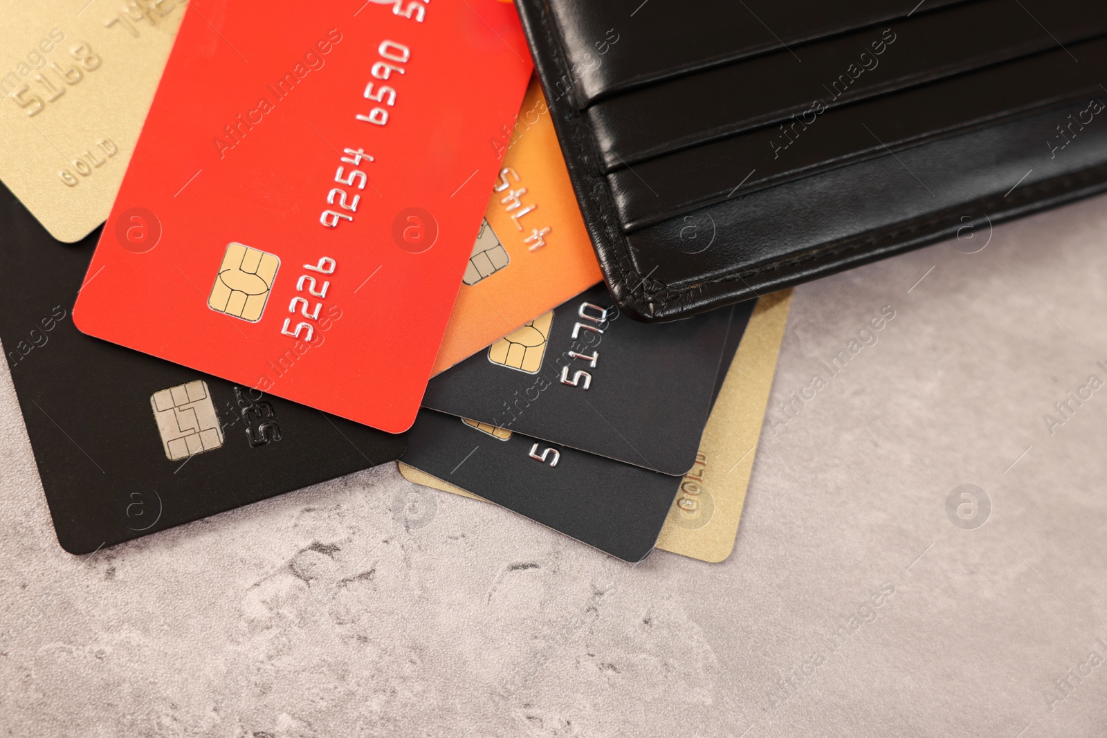 Photo of Many different credit cards and leather wallet on grey table, top view