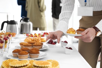 Woman taking snack during coffee break, closeup