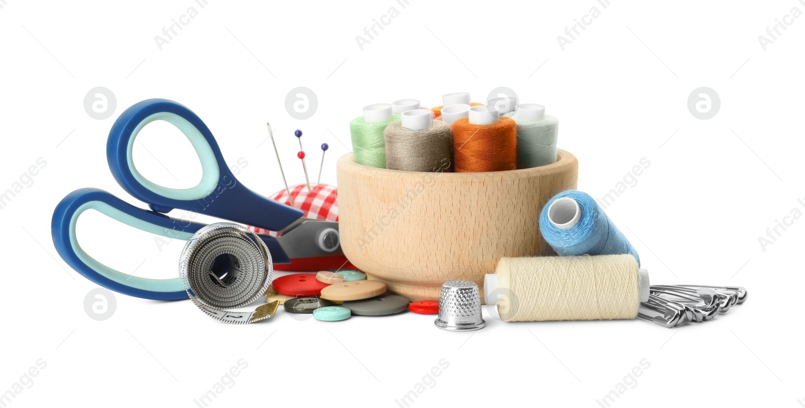 Photo of Spools of threads and sewing tools on white background