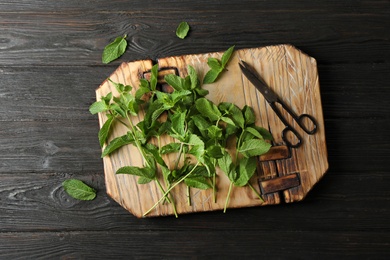 Photo of Fresh mint on wooden board, top view